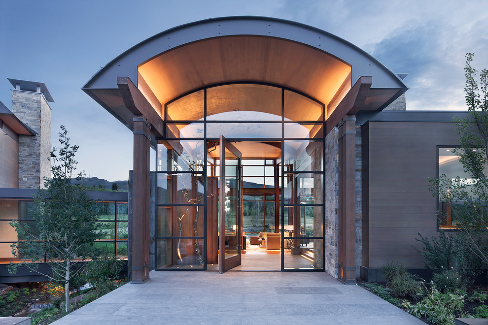 Design ideas for a country front door in Denver with a pivot front door, a glass front door and grey floor.