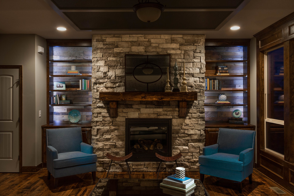 Inspiration for a large country open concept living room in Kansas City with dark hardwood floors, a standard fireplace, a stone fireplace surround and a wall-mounted tv.