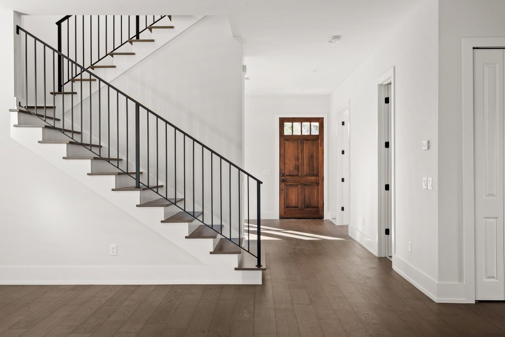 Large transitional medium tone wood floor and brown floor entry hall photo in Orlando with white walls and a dark wood front door