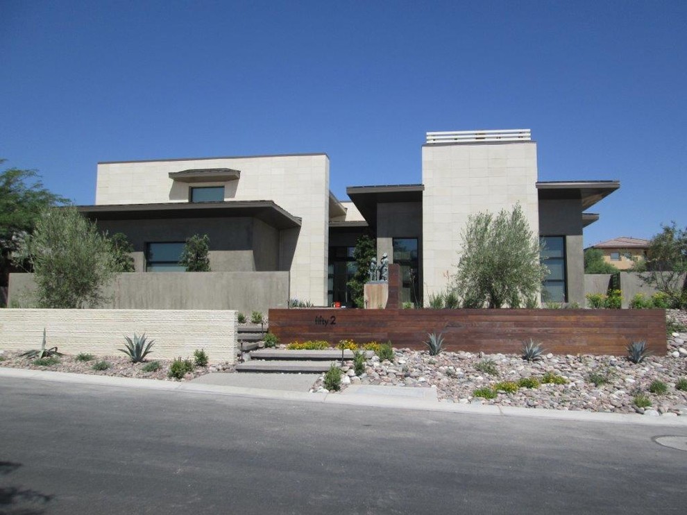 Design ideas for a mid-sized contemporary two-storey beige exterior in Las Vegas with concrete fiberboard siding and a flat roof.