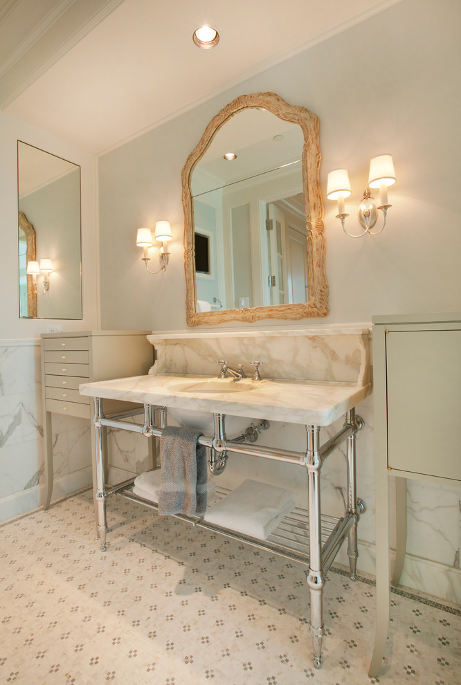 Inspiration for a large traditional master bathroom in Omaha with a pedestal sink, recessed-panel cabinets, white cabinets, engineered quartz benchtops, an undermount tub, a curbless shower, a two-piece toilet, white tile, stone tile, white walls and limestone floors.