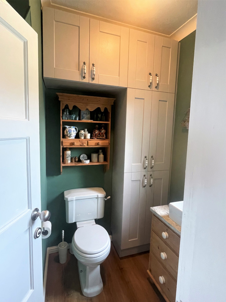 На фото: туалет среднего размера в классическом стиле с фасадами в стиле шейкер, раздельным унитазом, галечной плиткой, зелеными стенами и коричневым полом с