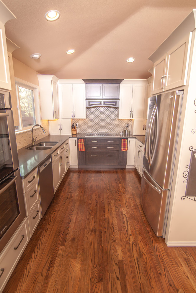 Mid-sized transitional u-shaped light wood floor eat-in kitchen photo in Boise with a double-bowl sink, shaker cabinets, white cabinets, quartz countertops, white backsplash, ceramic backsplash, stainless steel appliances and an island