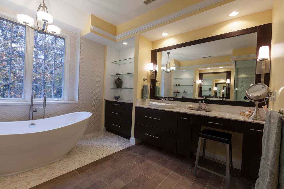 This is an example of a large contemporary master bathroom in New York with a vessel sink, flat-panel cabinets, dark wood cabinets, onyx benchtops, a freestanding tub, a double shower, beige tile, porcelain tile, yellow walls and porcelain floors.