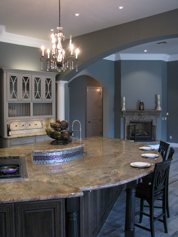 Example of a huge transitional l-shaped porcelain tile open concept kitchen design in Phoenix with an undermount sink, raised-panel cabinets, gray cabinets, granite countertops, gray backsplash, stone tile backsplash, stainless steel appliances and an island