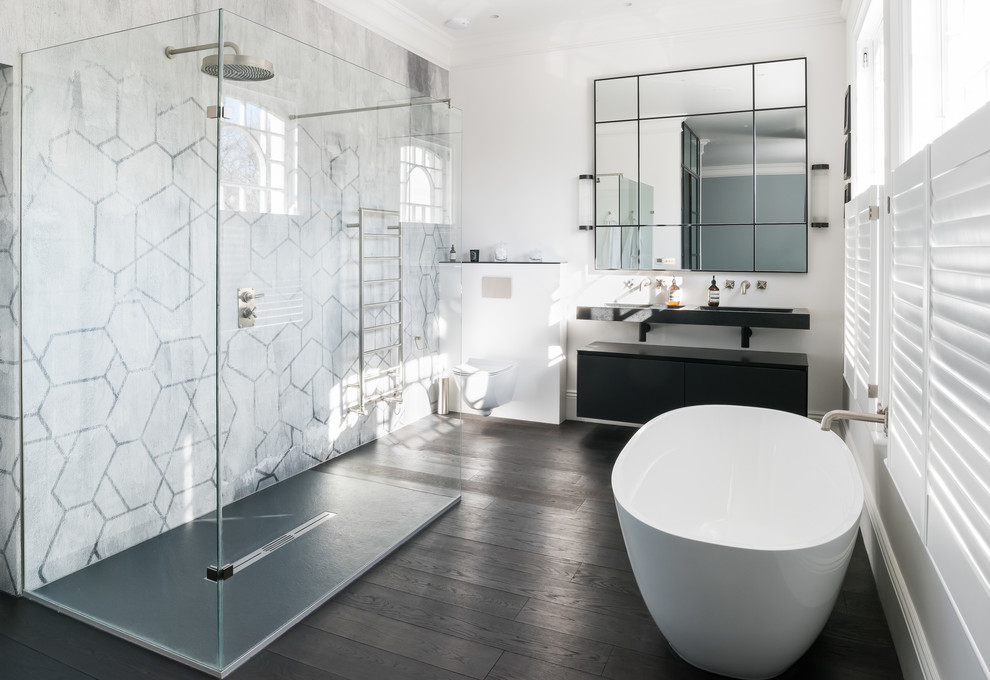 Photo of an expansive contemporary master bathroom in London with flat-panel cabinets, grey cabinets, a freestanding tub, an open shower, a wall-mount toilet, white walls, dark hardwood floors, a wall-mount sink, quartzite benchtops, brown floor, an open shower, grey benchtops and marble.