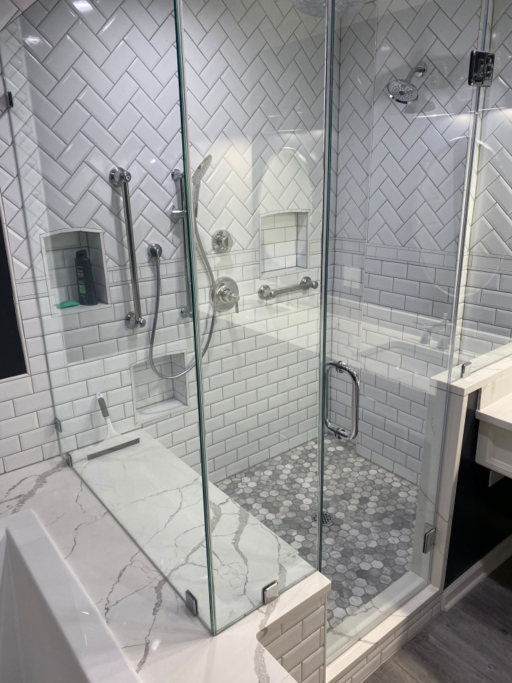 Photo of a mid-sized contemporary master bathroom in Chicago with recessed-panel cabinets, white cabinets, a hot tub, a double shower, a two-piece toilet, white tile, travertine, black walls, vinyl floors, an undermount sink, marble benchtops, grey floor, a hinged shower door, white benchtops, a niche, a double vanity and a built-in vanity.
