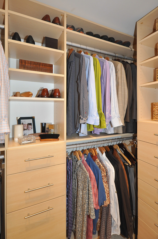This is an example of a mid-sized contemporary men's walk-in wardrobe in Minneapolis with flat-panel cabinets, light wood cabinets and carpet.