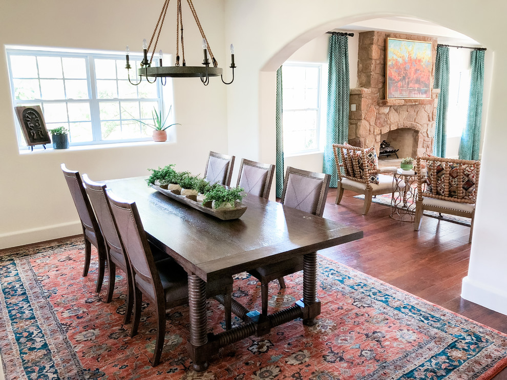 Inspiration for a mid-sized mediterranean separate dining room in Austin with white walls, dark hardwood floors, no fireplace and brown floor.
