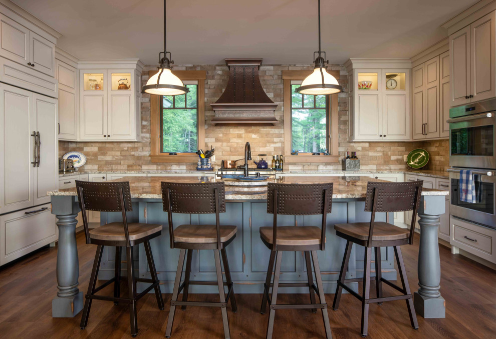 Eat-in kitchen - large rustic u-shaped medium tone wood floor and brown floor eat-in kitchen idea with a farmhouse sink, beaded inset cabinets, multicolored backsplash, stone tile backsplash, stainless steel appliances and an island