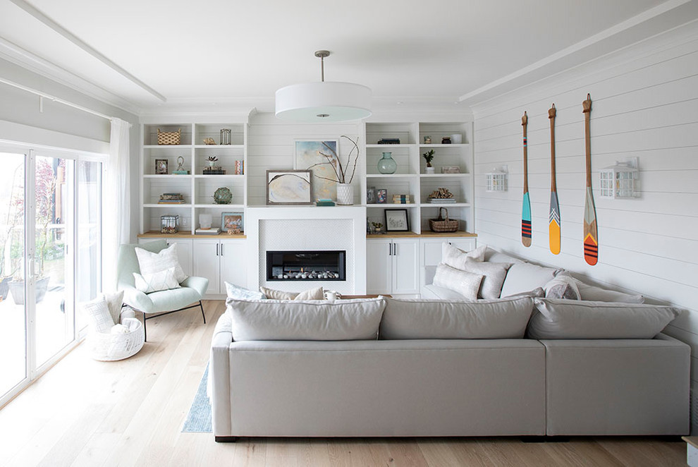 Mid-sized beach style light wood floor and beige floor family room photo in Edmonton with white walls, a ribbon fireplace, a tile fireplace and no tv