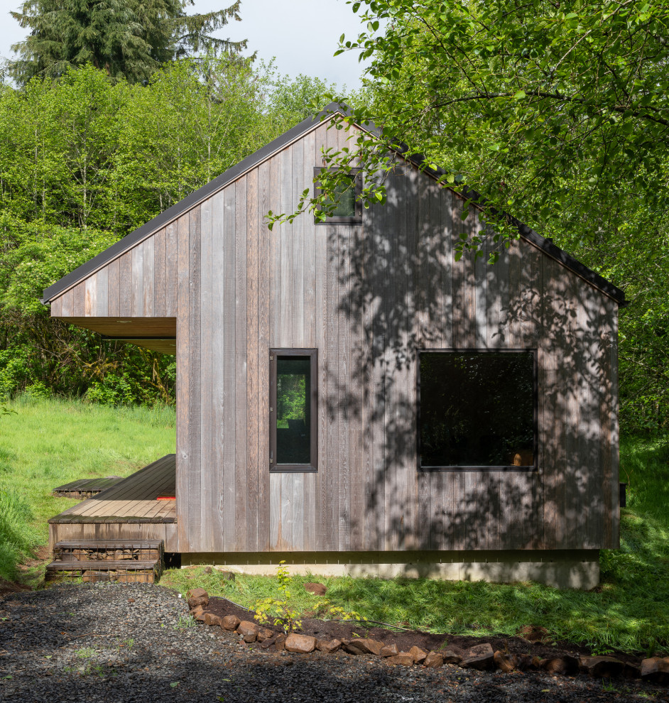 Inspiration för ett litet rustikt hus, med allt i ett plan, sadeltak och tak i metall