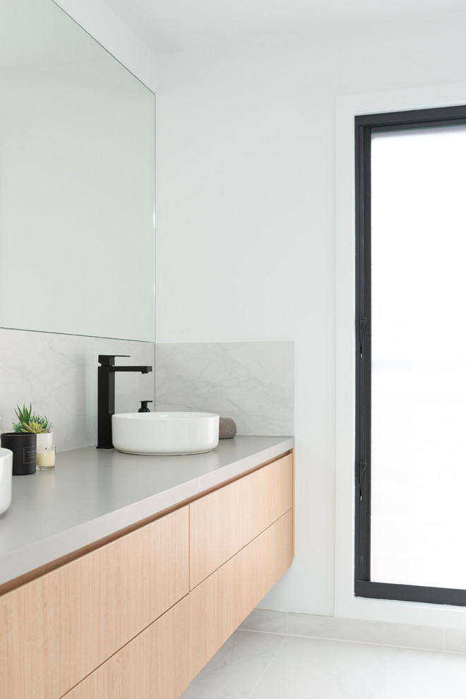 Inspiration for a mid-sized contemporary master bathroom in Sydney with flat-panel cabinets, light wood cabinets, an alcove shower, a one-piece toilet, white tile, ceramic tile, white walls, ceramic floors, a console sink, engineered quartz benchtops, white floor, an open shower and grey benchtops.