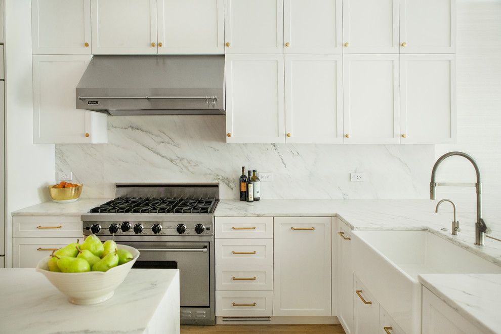 Inspiration for a mid-sized contemporary l-shaped eat-in kitchen remodel in New York with a farmhouse sink, shaker cabinets, white cabinets, marble countertops, white backsplash, marble backsplash, stainless steel appliances, an island and white countertops