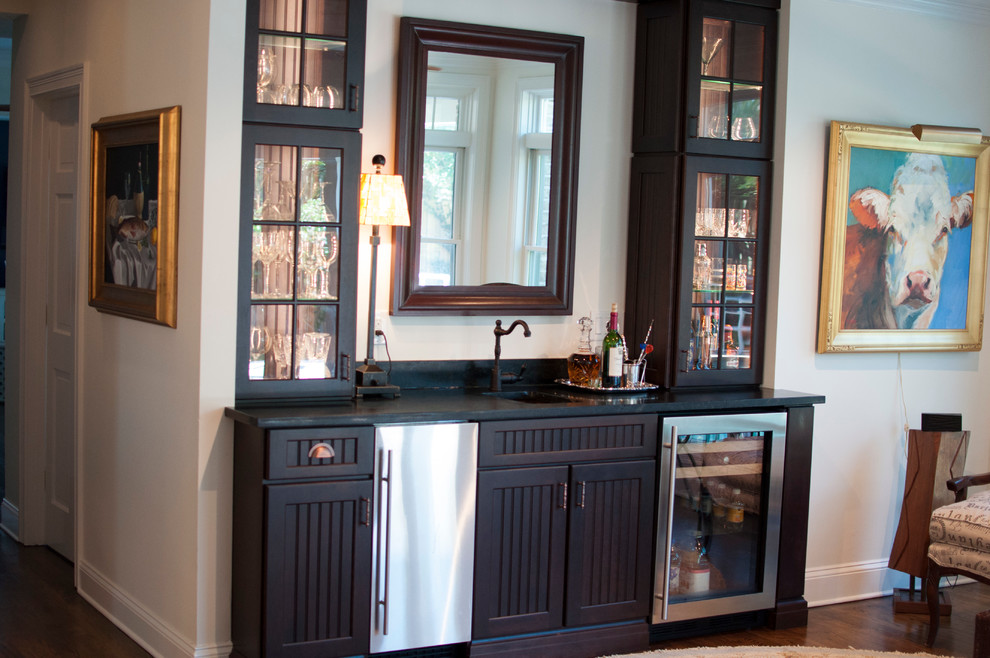Inspiration for a large contemporary single-wall wet bar in Jacksonville with an undermount sink, black cabinets, dark hardwood floors and glass-front cabinets.