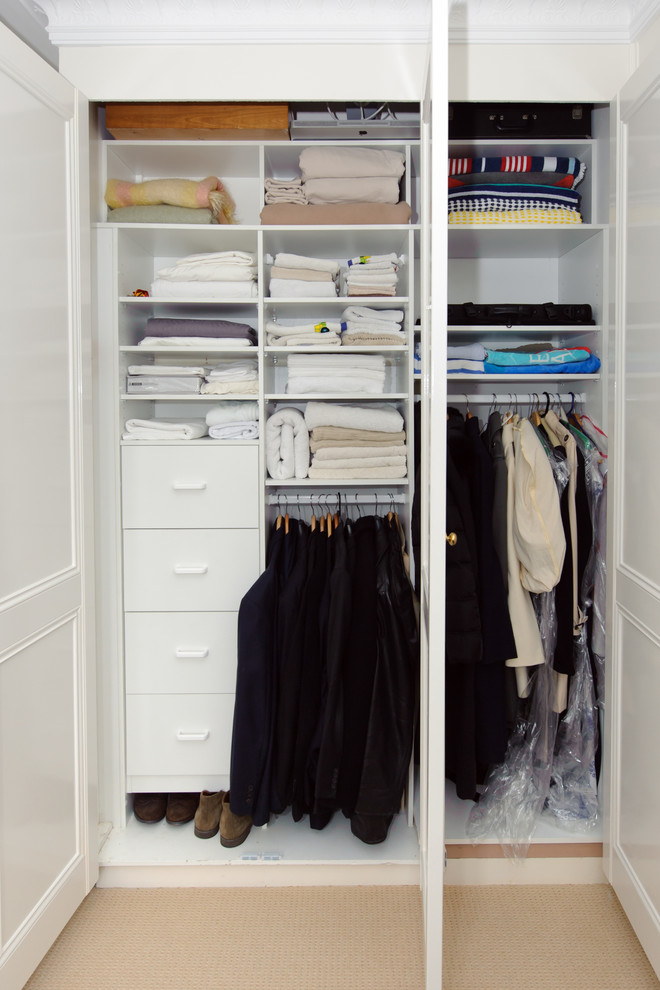 Inspiration for a small traditional gender-neutral built-in wardrobe in Sydney with flat-panel cabinets, white cabinets and carpet.