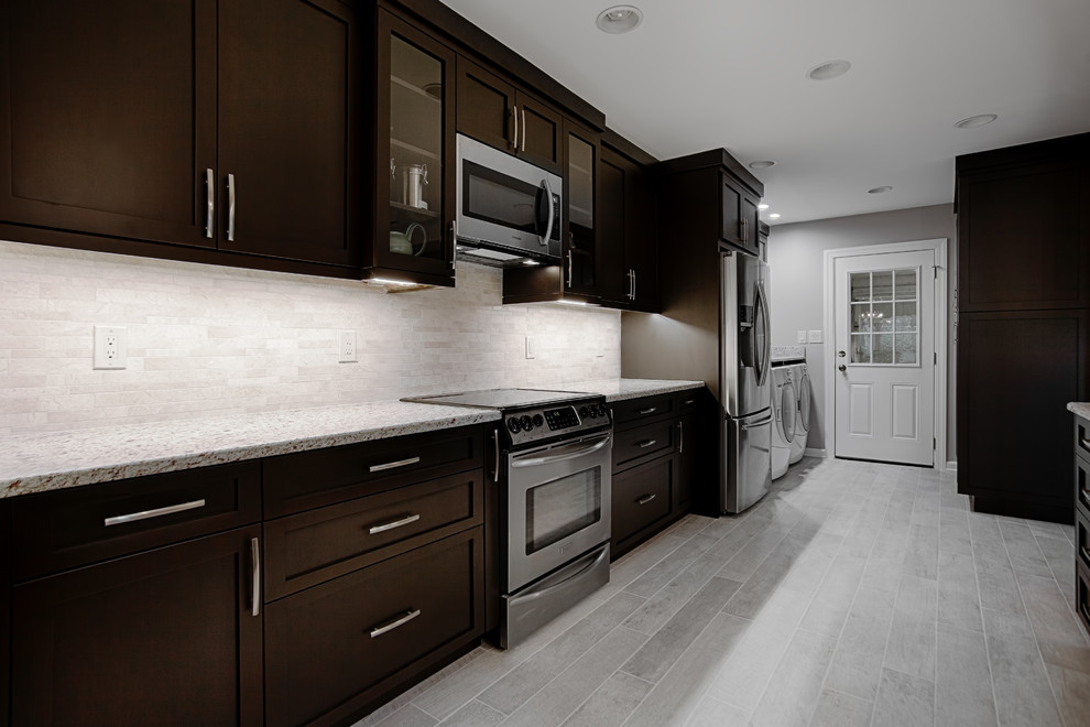 Example of a mid-sized trendy eat-in kitchen design in Charlotte with dark wood cabinets, granite countertops, white backsplash, stainless steel appliances and an island