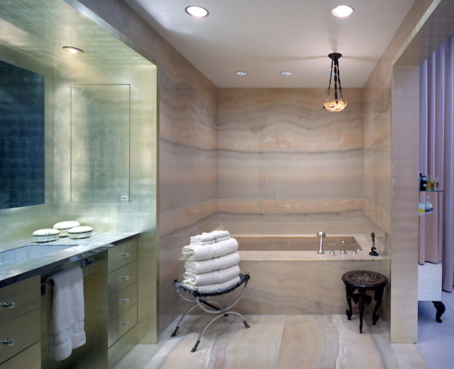 Inspiration for a mid-sized contemporary master bathroom in New York with flat-panel cabinets, grey cabinets, an alcove tub, beige tile, limestone, beige walls, limestone floors, an undermount sink, soapstone benchtops and beige floor.
