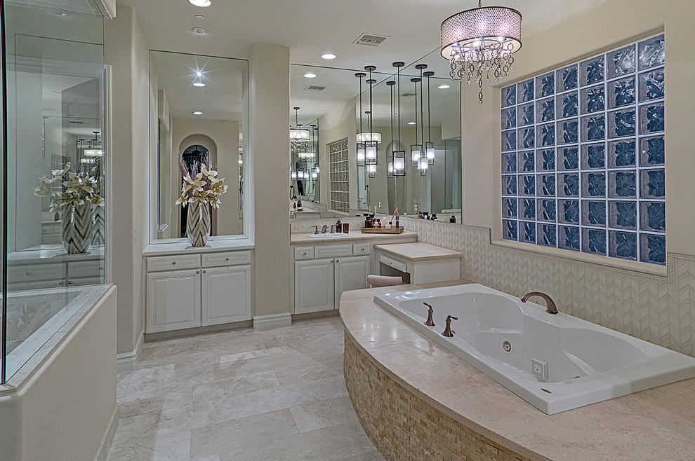 Photo of a large traditional master bathroom in Phoenix with recessed-panel cabinets, white cabinets, a hot tub, a corner shower, a one-piece toilet, beige tile, porcelain tile, beige walls, vinyl floors, a drop-in sink and soapstone benchtops.