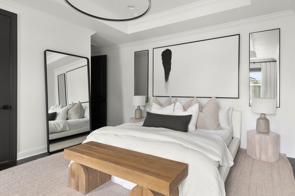 Idée de décoration pour une chambre parentale minimaliste de taille moyenne avec un mur blanc, parquet foncé et un sol marron.