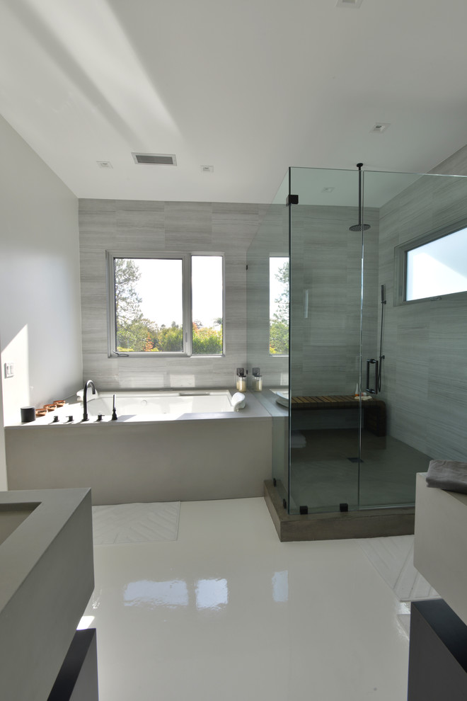 This is an example of a large modern master bathroom in Los Angeles with open cabinets, black cabinets, a hot tub, an alcove shower, grey walls, a trough sink, solid surface benchtops, gray tile, porcelain tile, porcelain floors, white floor and a hinged shower door.