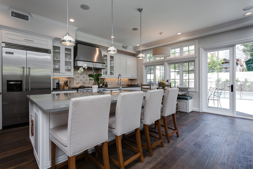 Design ideas for a large traditional single-wall open plan kitchen in Los Angeles with white cabinets, stainless steel appliances, medium hardwood floors and with island.