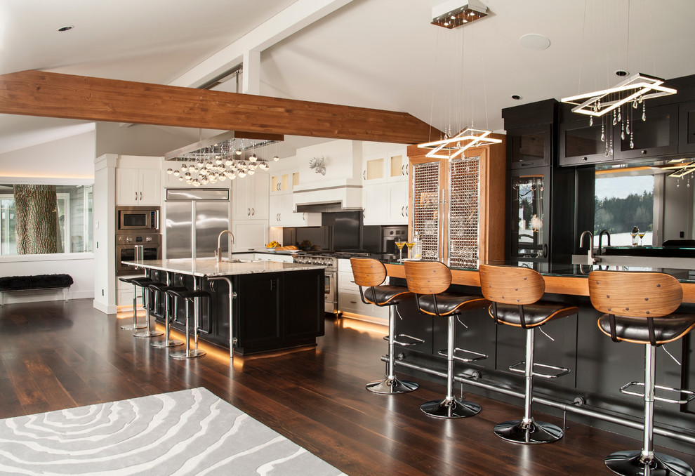 Design ideas for a mid-sized contemporary galley open plan kitchen in Seattle with an undermount sink, shaker cabinets, white cabinets, granite benchtops, black splashback, stone slab splashback, stainless steel appliances, dark hardwood floors and with island.