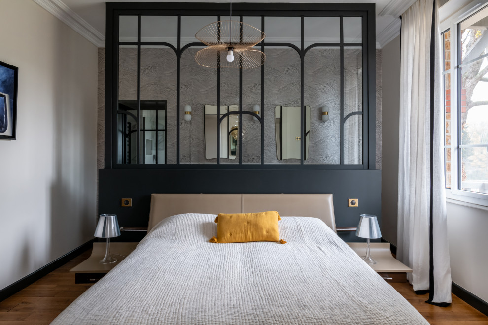 Geräumiges Modernes Hauptschlafzimmer mit beiger Wandfarbe, hellem Holzboden, Kamin, Kaminumrandung aus Stein, beigem Boden und Tapetenwänden in Paris