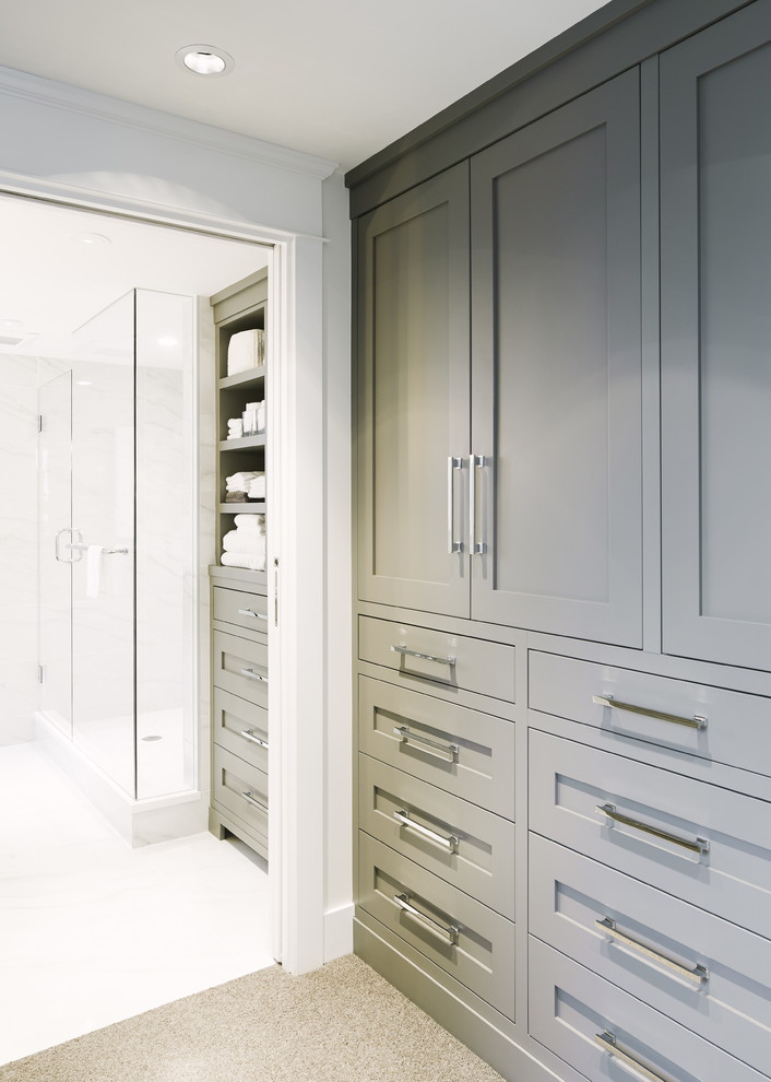 This is an example of a small transitional dressing room in Vancouver with shaker cabinets, grey cabinets and light hardwood floors.