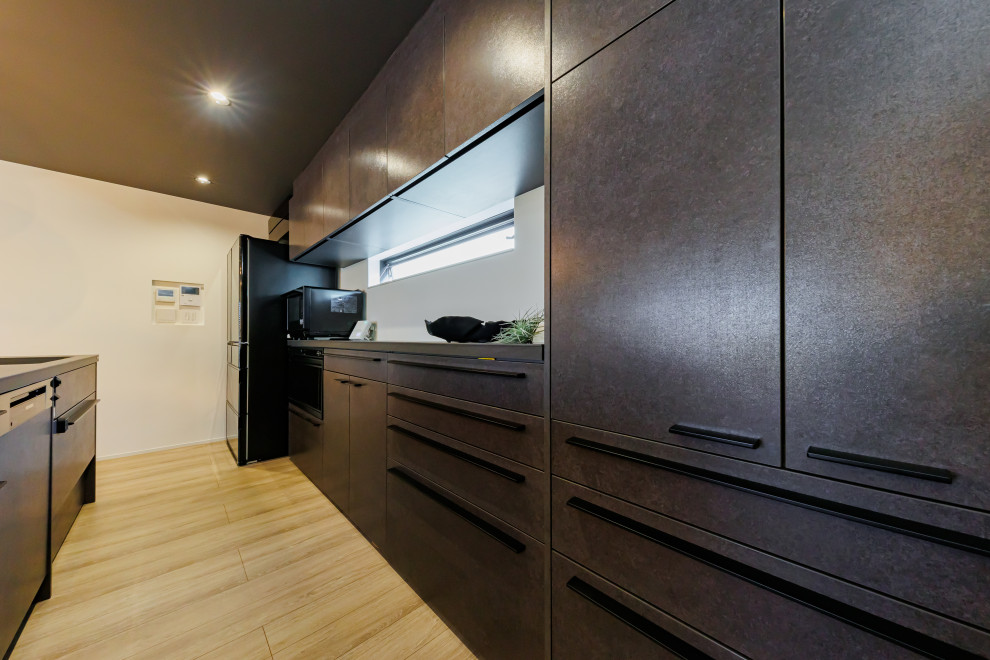Ispirazione per una cucina moderna di medie dimensioni con ante nere, paraspruzzi nero, pavimento in legno massello medio, pavimento marrone, top nero e soffitto in carta da parati