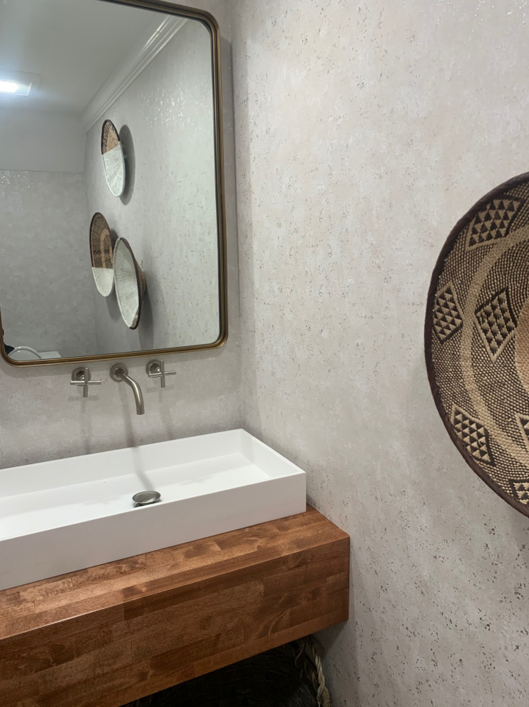 Cette image montre un petit WC et toilettes traditionnel en bois brun avec un mur gris, un plan vasque, un plan de toilette en bois, un plan de toilette marron, meuble-lavabo suspendu et du papier peint.