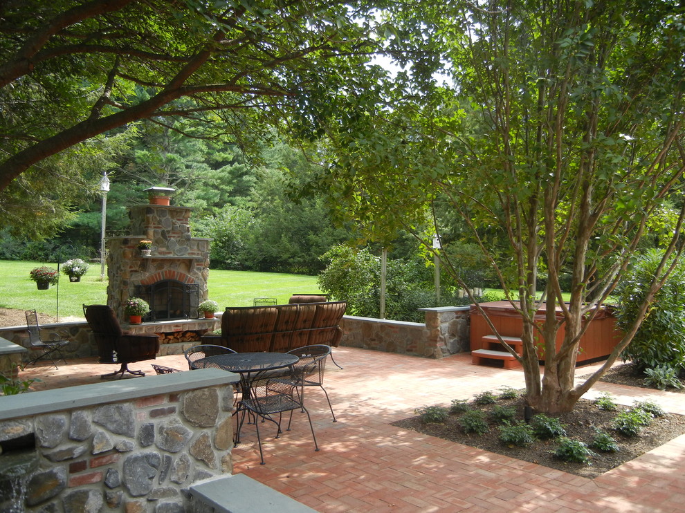 Photo of a small traditional backyard patio in Philadelphia with with fireplace, brick pavers and no cover.
