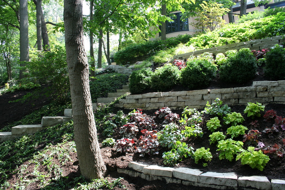 Design ideas for an expansive traditional sloped shaded garden in Chicago with natural stone pavers.