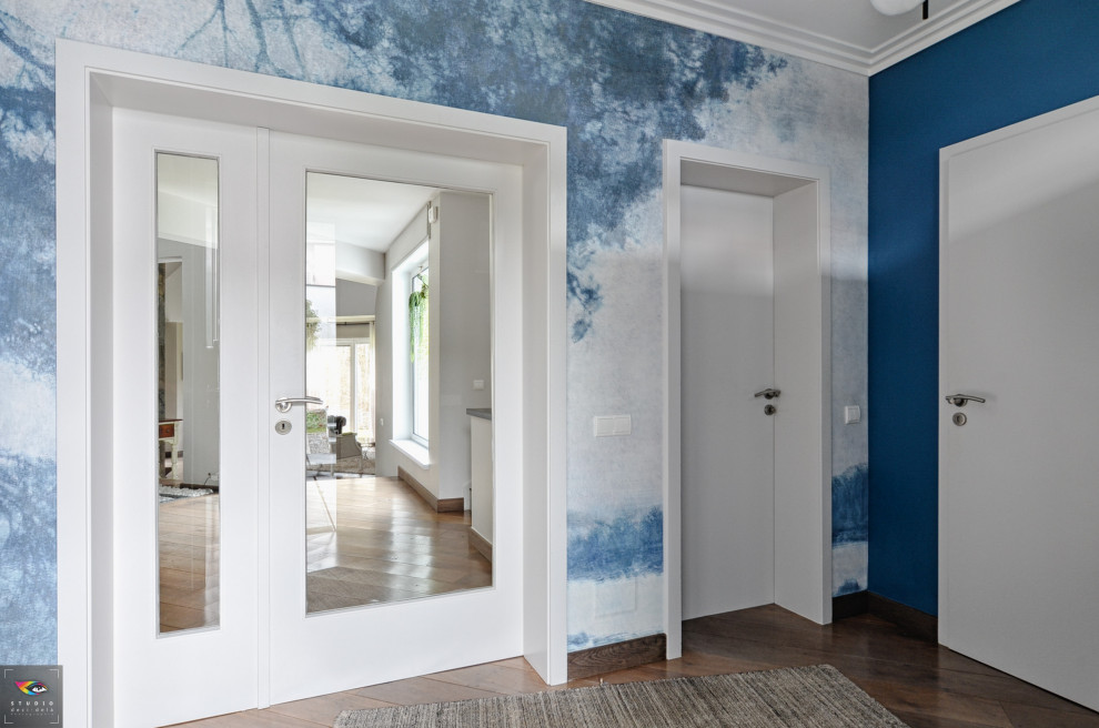 Transitional foyer in Other with blue walls, plywood floors and wallpaper.