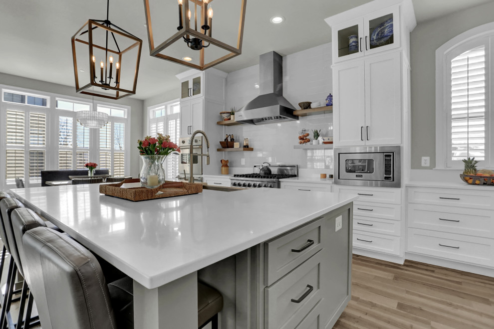 Inspiration for a mid-sized transitional single-wall medium tone wood floor and brown floor enclosed kitchen remodel in DC Metro with shaker cabinets, gray cabinets, quartz countertops, white backsplash, quartz backsplash, stainless steel appliances, no island and white countertops