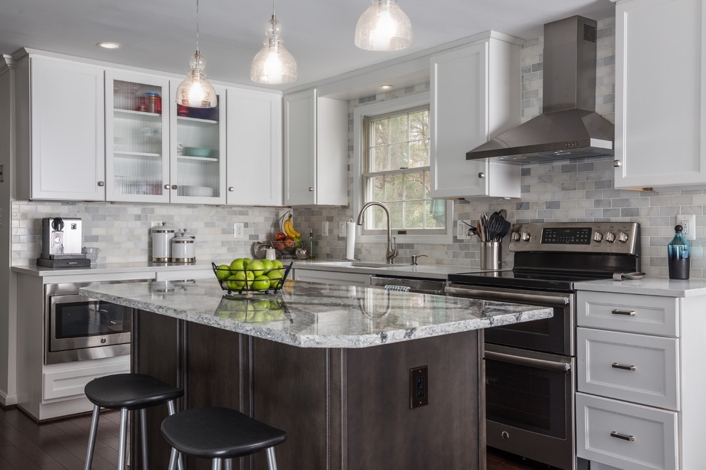 Mid-sized transitional l-shaped eat-in kitchen in DC Metro with an undermount sink, shaker cabinets, white cabinets, quartz benchtops, white splashback, stone tile splashback, stainless steel appliances, dark hardwood floors, with island and brown floor.
