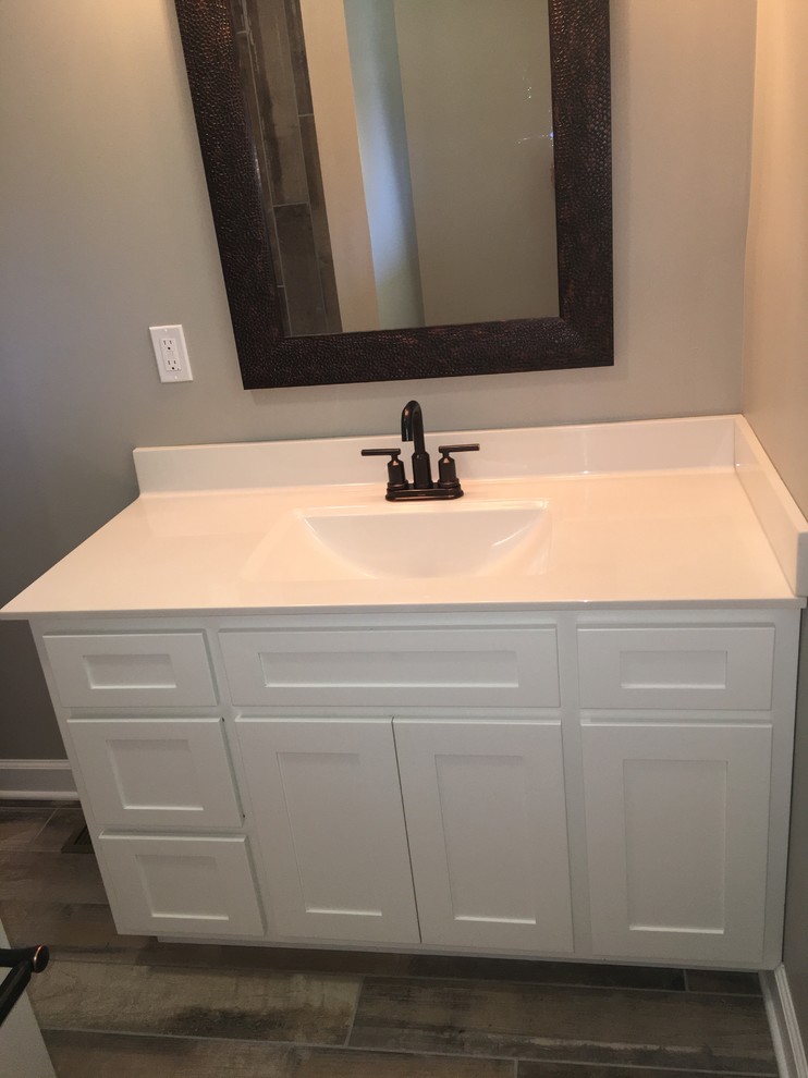 Inspiration for a mid-sized transitional 3/4 porcelain tile and brown floor alcove shower remodel with shaker cabinets, white cabinets, gray walls, an integrated sink, solid surface countertops and a hinged shower door