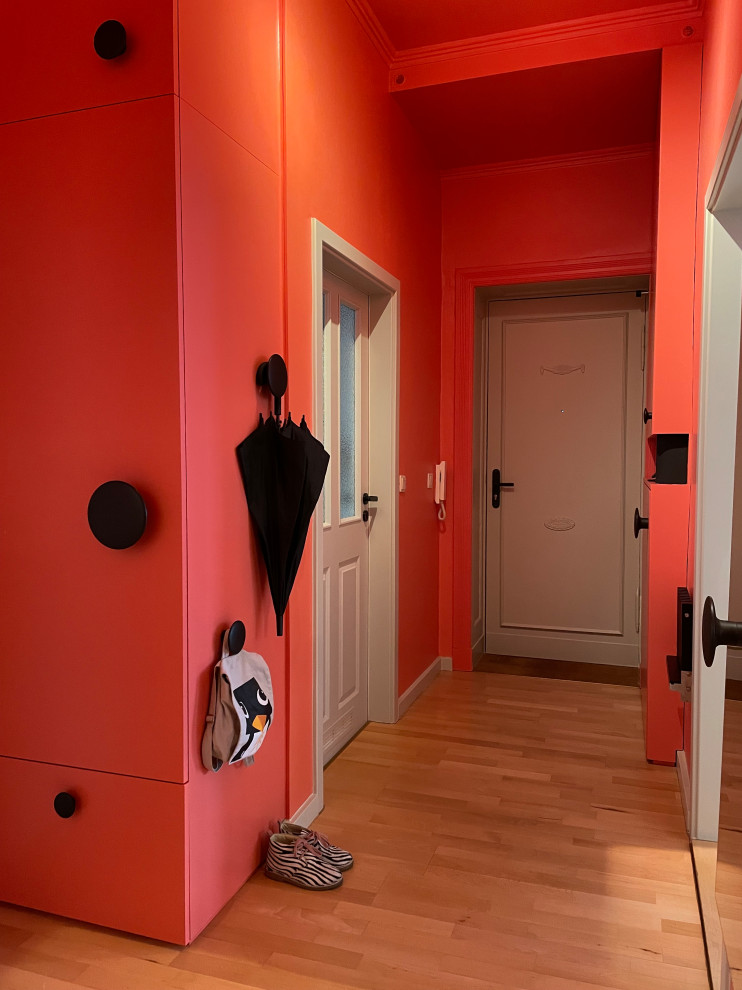 Immagine di un ingresso o corridoio minimal di medie dimensioni con pareti rosa, pavimento in legno massello medio e pavimento marrone