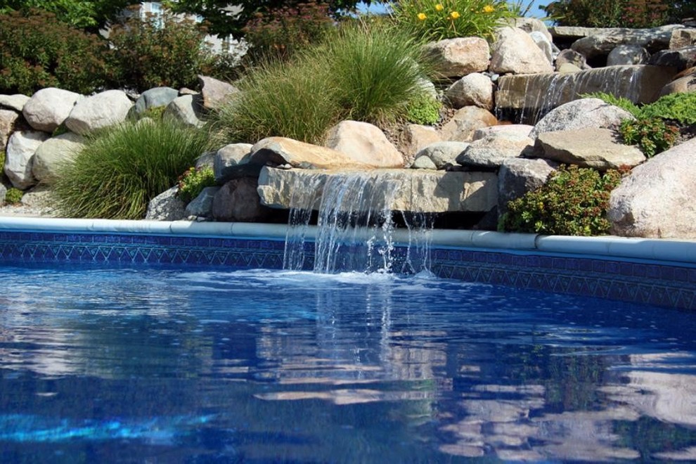 Inspiration for a large backyard custom-shaped pool remodel in Grand Rapids