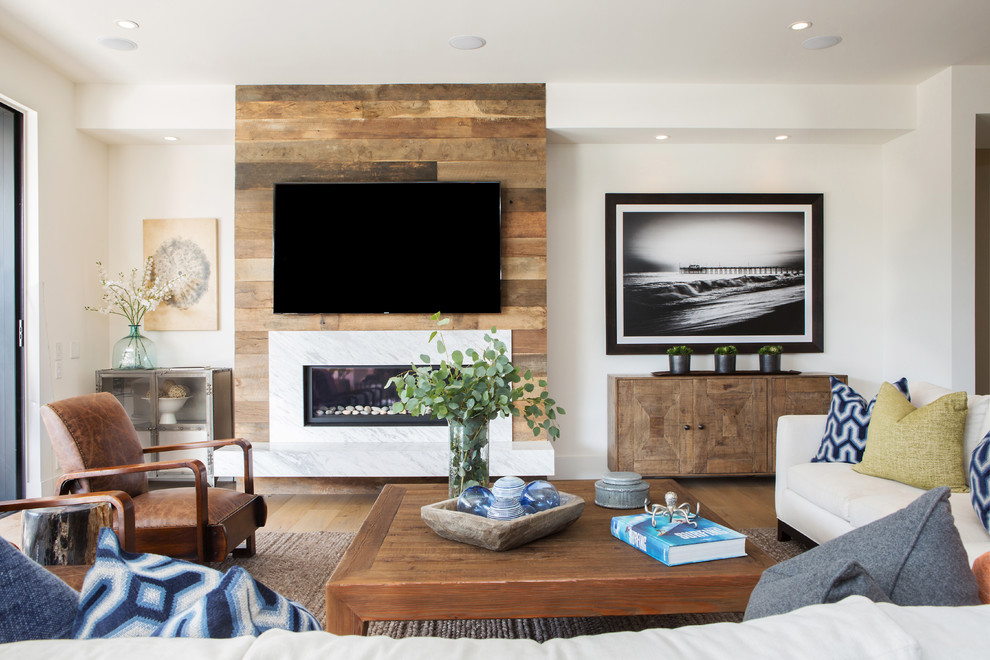 Modern family room in Orange County with white walls, a ribbon fireplace, a wall-mounted tv and a stone fireplace surround.