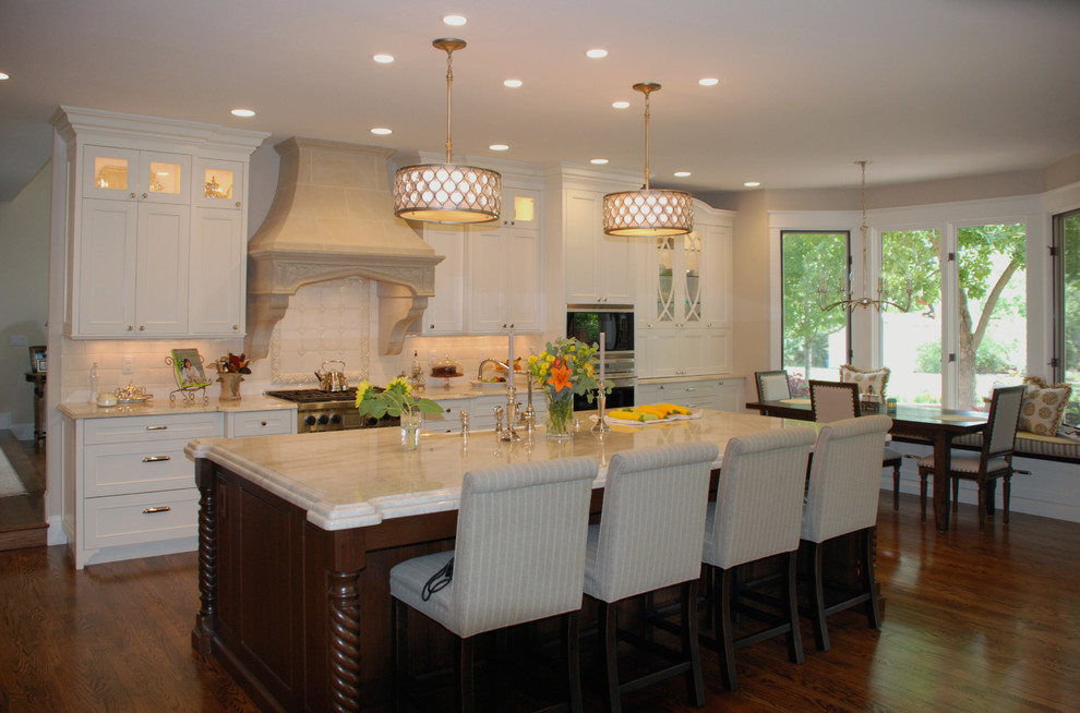 Inspiration for a traditional kitchen in Denver with panelled appliances, medium hardwood floors and with island.