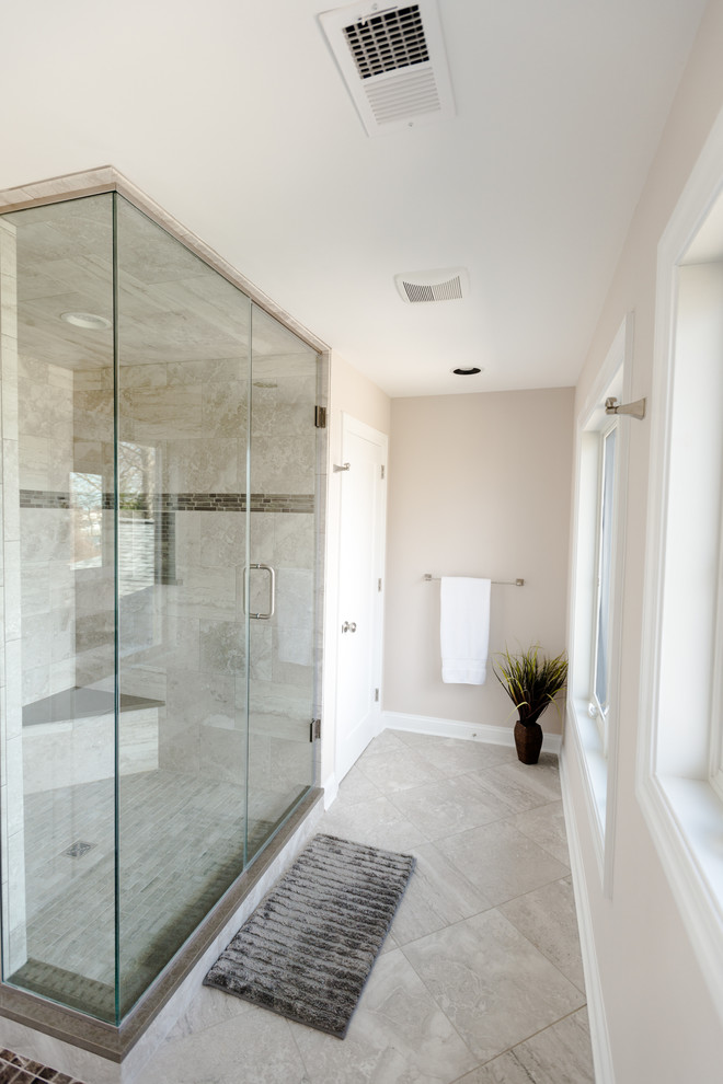 Inspiration for a large transitional master bathroom in Baltimore with white cabinets, a freestanding tub, a corner shower, beige walls, limestone floors, marble benchtops, grey floor and a hinged shower door.