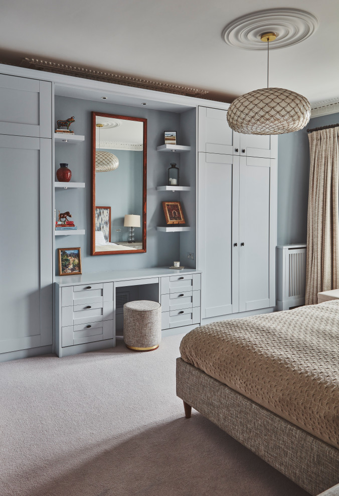 This is an example of a medium sized classic master bedroom in London with blue walls, carpet, beige floors and no fireplace.