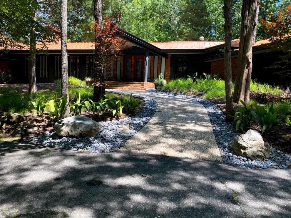 Photo of a large midcentury front yard partial sun xeriscape in Raleigh with with waterfall and river rock.