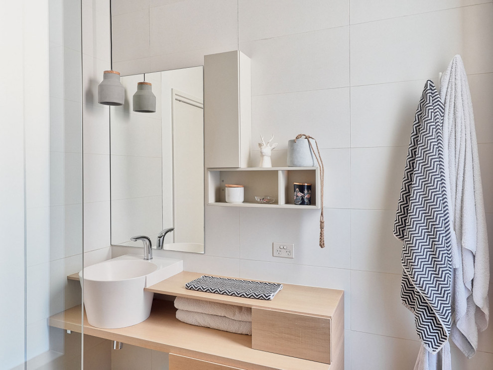Photo of a mid-sized scandinavian bathroom in Melbourne with light wood cabinets, a freestanding tub, a corner shower, black tile, grey walls, grey floor, an open shower, grey benchtops, a single vanity, a built-in vanity and flat-panel cabinets.