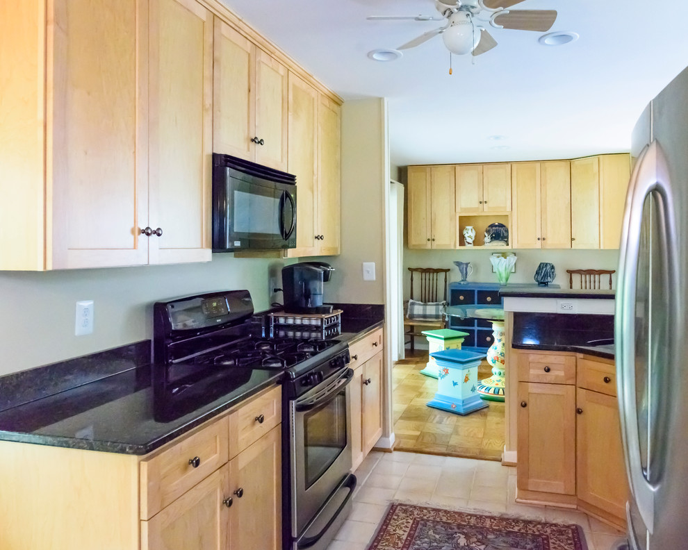 Small transitional galley porcelain tile eat-in kitchen photo in DC Metro with an undermount sink, flat-panel cabinets, light wood cabinets, granite countertops, black backsplash, stainless steel appliances and no island