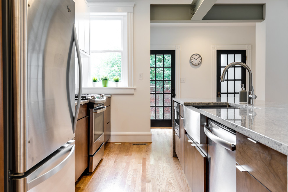 Inspiration for a mid-sized transitional single-wall eat-in kitchen in Richmond with an undermount sink, flat-panel cabinets, medium wood cabinets, granite benchtops, white splashback, ceramic splashback, stainless steel appliances, light hardwood floors, with island and grey benchtop.
