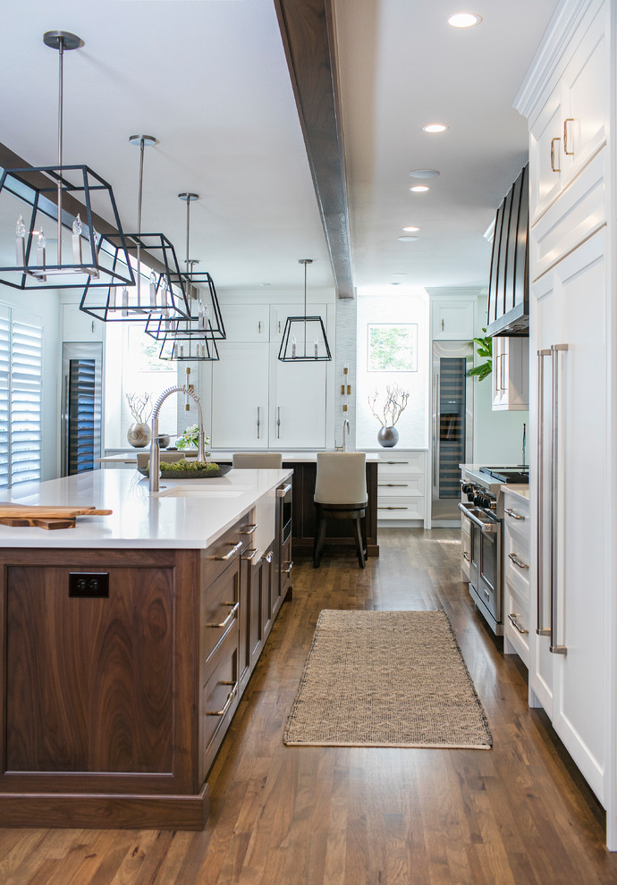 Example of a large transitional galley medium tone wood floor and brown floor eat-in kitchen design in Denver with recessed-panel cabinets, white cabinets, quartz countertops, stainless steel appliances, an undermount sink and an island