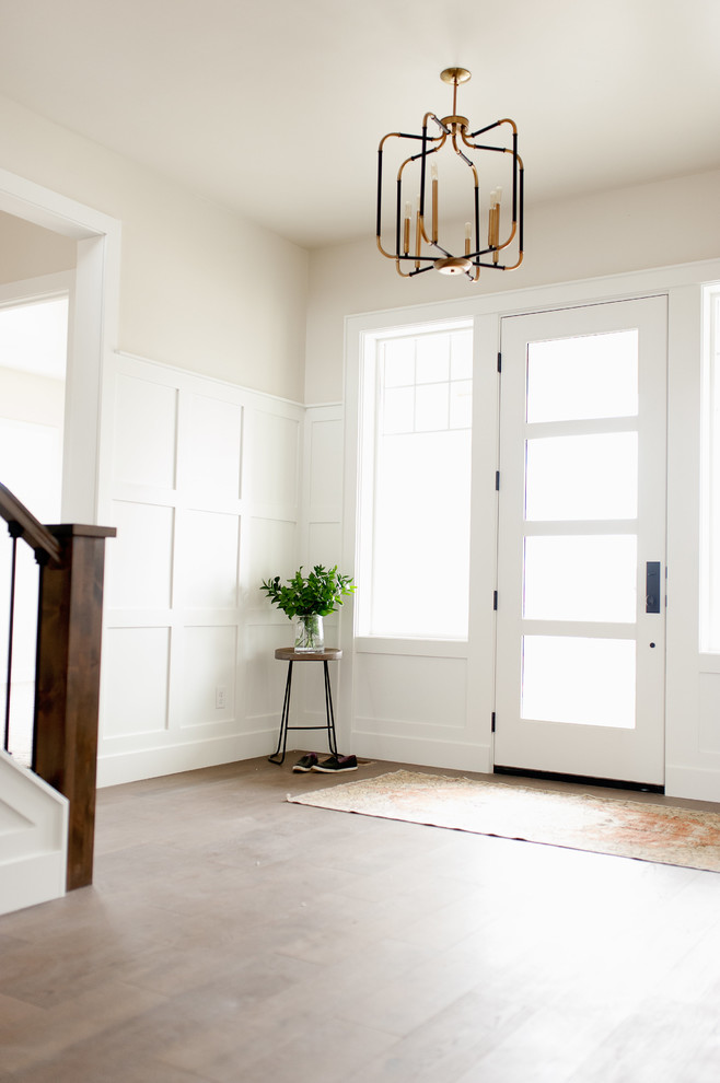 This is an example of a country entryway in Boise with beige walls, medium hardwood floors, a single front door and a glass front door.