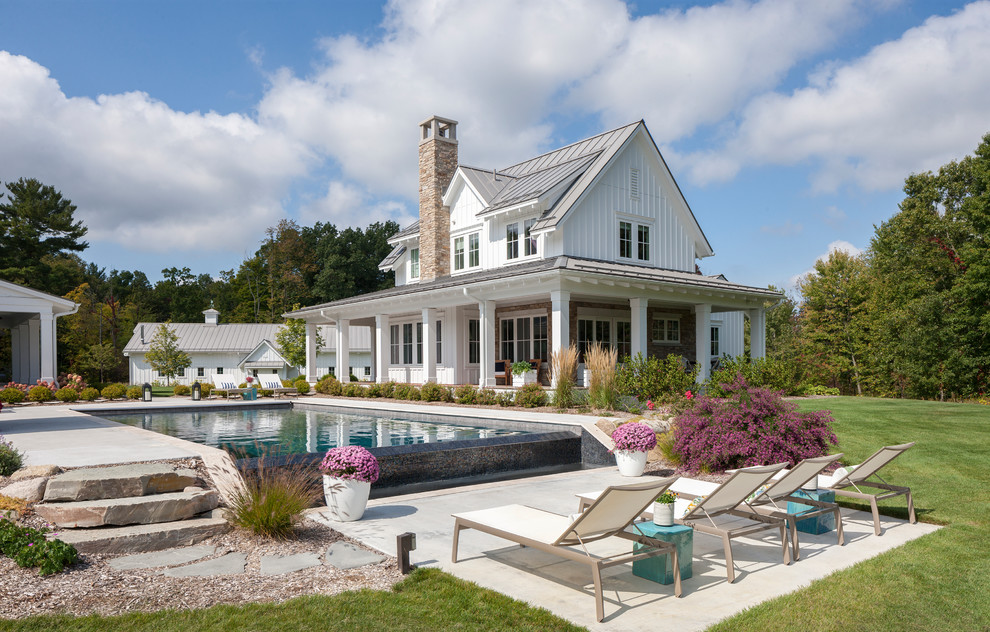 Inspiration for a huge farmhouse white two-story wood house exterior remodel in Grand Rapids with a metal roof